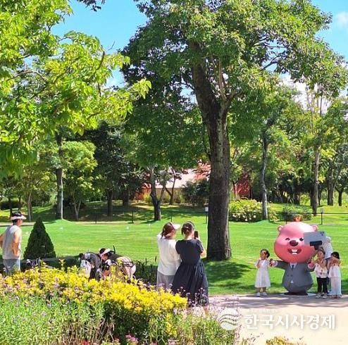 순천만국가정원을 방문한 관람객들이 정원워케이션에서 잔망루피와 함께 기념사진을 찍고 있다