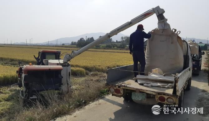 콤바인을 통해 벼를 수확하고 있는 농업인 모습