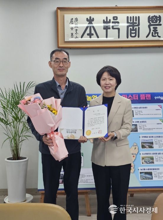 이현주 농업기술센터 소장이 9월 민원처리 단축 마일리지제 우수공무원 김정훈 주무관에게 시상하고 있다.