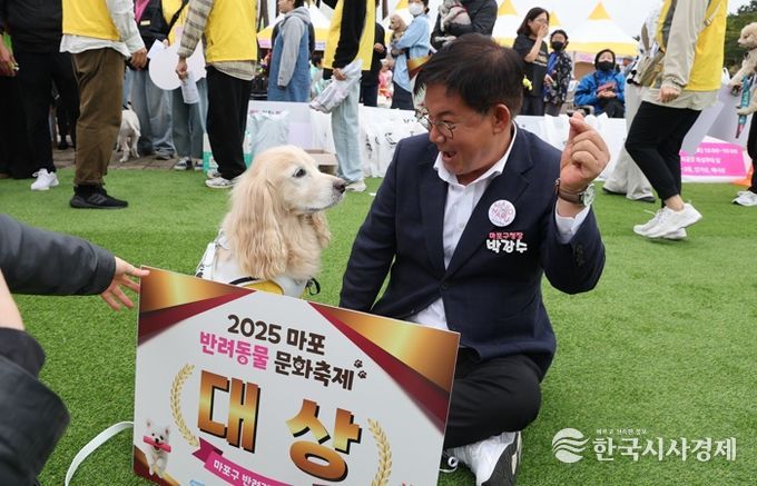 박강수 마포구청장이 반려견 체육대회에서 대상을 수상한 반려견과 함께 기념 촬영을 하고 있다.