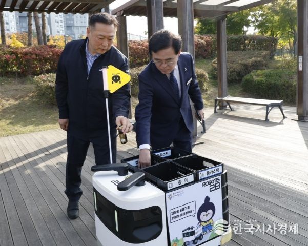 진교훈 서울 강서구청장(오른쪽)이 마곡하늬공원에서 열린 ‘AI 기반 자율주행 로봇서비스 실증 시연회’에서 빈 캔을 수거함에 넣고 있다.