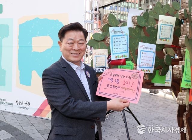 박승원 광명시장이 지난 1일 철산상업지구 원형광장에서 열린 ‘2025 공정무역 2주간 캠페인-포트나잇’의 당일 캠페인에 참석해 공정무역 소비 실천을 다짐하는 서약문을 들고 기념사진을 촬영하고 있다.