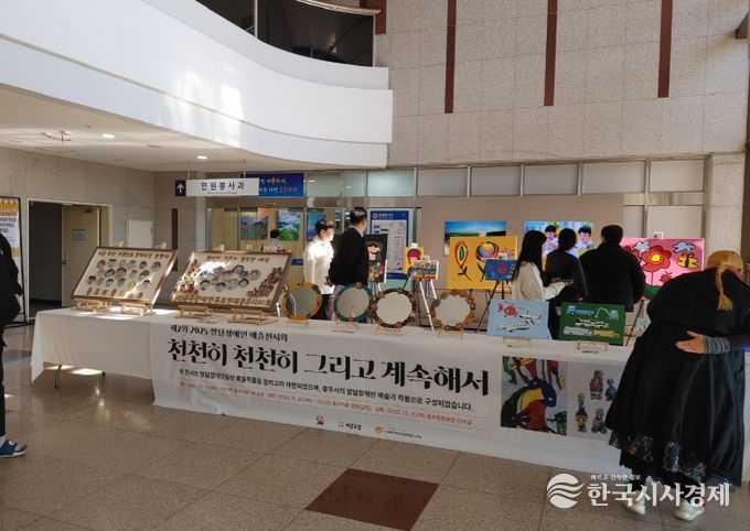 충주시청서 제2회 발달장애인 예술전시회 개최(시민들이 전시회 작품을 보고 있다)