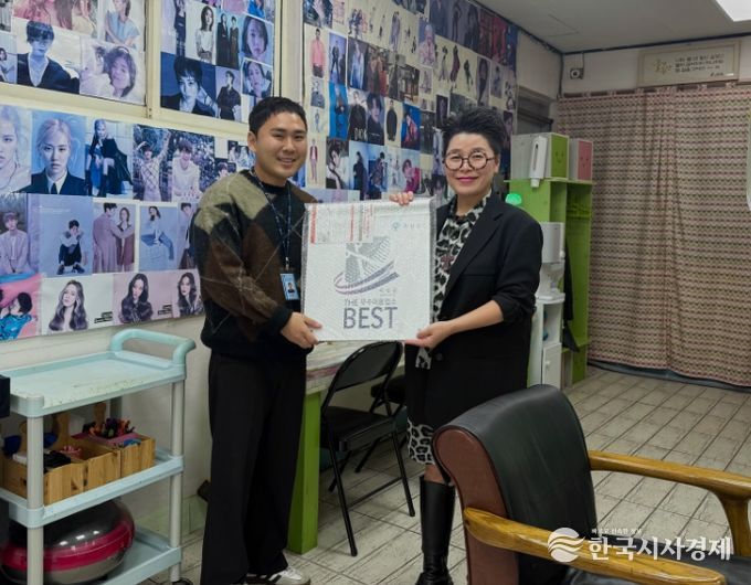 군 관계자가 공중위생서비스 평가 우수업소에 현판을 건네고 있다