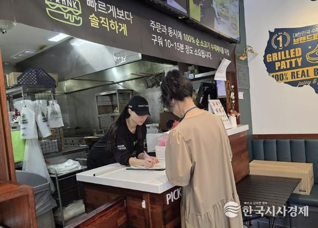성남시 어린이 기호식품 전담관리원이 지난 9월 학교 주변 햄버거 판매점에서 영업자와 종업원의 건강진단 실시 여부를 점검하고 있다