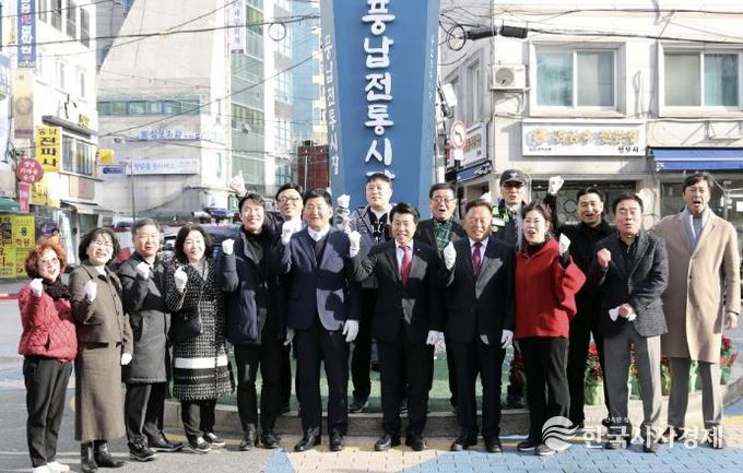 서강석 송파구청장(가운데)이 풍납시장 간판어닝 개선사업 준공현장에 방문해 주민들과 함께 기념촬영을 하고 있다