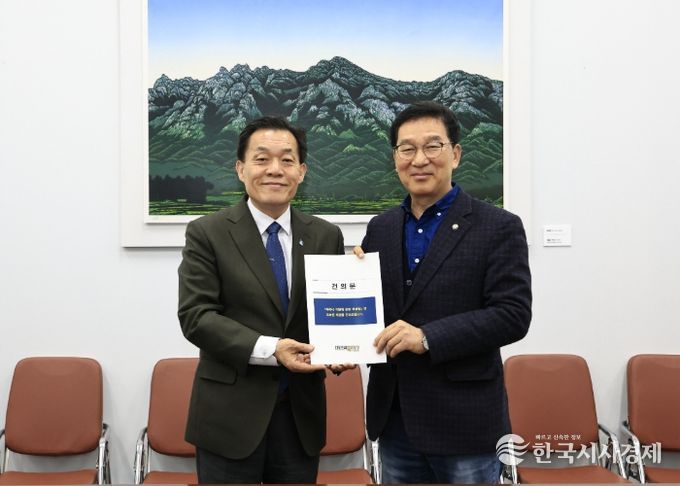 이재준 수원시장(왼쪽)이 신정훈 국회 행정안전위원장에게 건의문을 전달하고 있다.