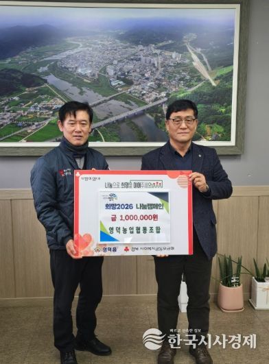 농업협동조합장 우영환(우측)이 장덕식 영덕읍장에게 성금을 전달하고 있다.