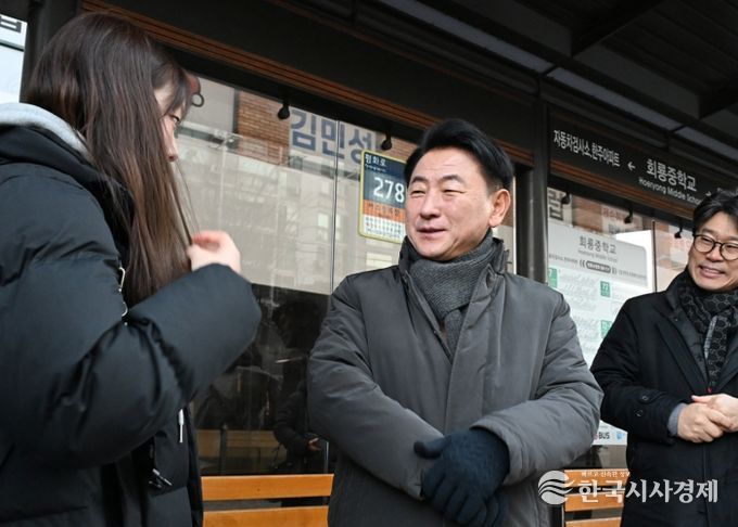 김동근 시장이 1월 6일 133번 시내버스 정류소에서 한 학생에게 통학 환경에 대한 의견을 듣고 있다.
