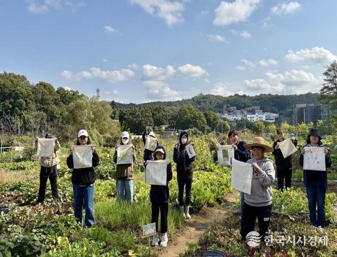 2025년 주민공모사업 ‘실행기’ 참여 주민들이 천가방(에코백)을 들고 기념촬영을 하고 있다