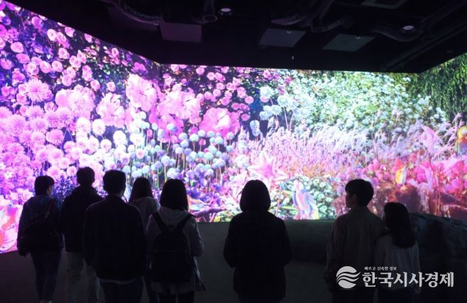경주 동궁원 내 복합문화정원 ‘라원’ 전시관에서 관람객들이 AI 미디어아트로 구현된 ‘빛의 갤러리’를 감상하고 있다.