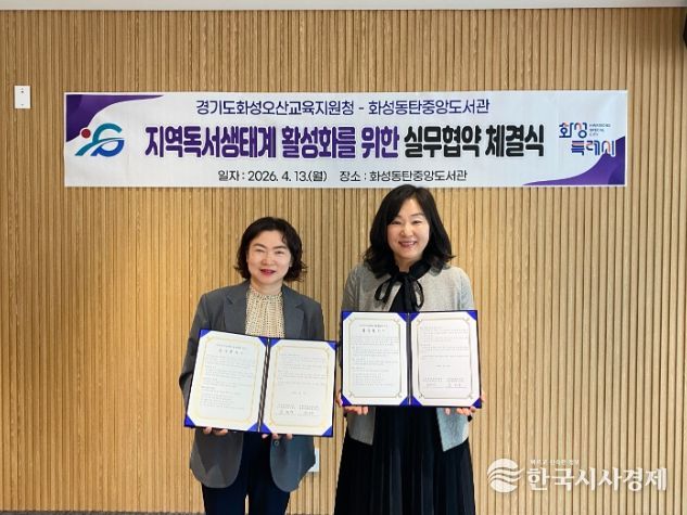 윤미영 화성특례시 도서관정책과장(왼쪽)과 권대은 화성오산교육지원청 평생교육건강과장(오른쪽)이 지역 독서문화 진흥을 위한 실무협약을 체결하고 협약서를 들어 보이며 기념촬영을 하고 있다.